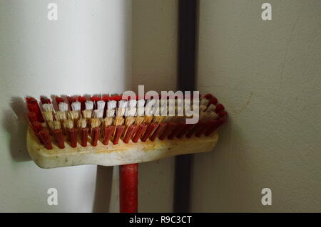 Stock Bürste mit roten langen Griff lehnte sich auf Badezimmer Wand Stockfoto