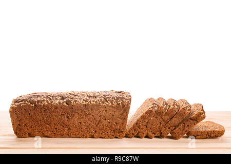 Lange Roggenbrot in Scheiben geschnitten auf hölzernen Tisch von der Seite. Selektiver Fokus auf das Brot. Auf weiß Isoliert Stockfoto