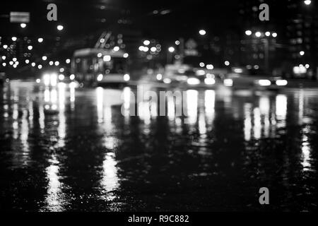 Regnerische Stadt Straße bei Nacht mit Licht Reflexion. Abstrakte defokussierten Schwarz/Weiß-Bild Stockfoto