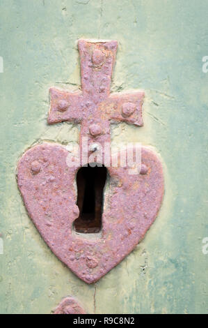 Vintage Schlüsselloch mit Herz und Kreuz in eine alte Tür. Stockfoto
