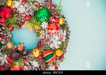 Ansicht von oben Schöne traditionelle helle Weihnachten Kranz mit tannenzapfen eingerichtet, Zweige, Beeren, Kugeln, Sterne, Fichte, dekorative Biere auf Blau zurück Stockfoto