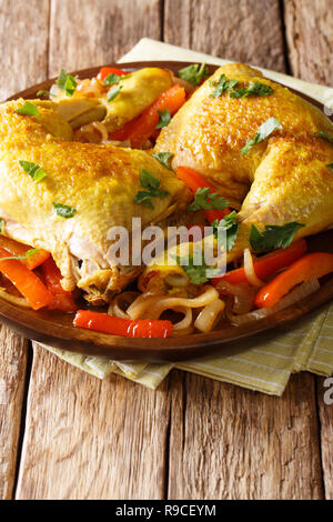Leckere Hähnchenschenkel geschmort mit Safran und Gemüse close-up auf einem Teller auf den Tisch. Vertikale Stockfoto