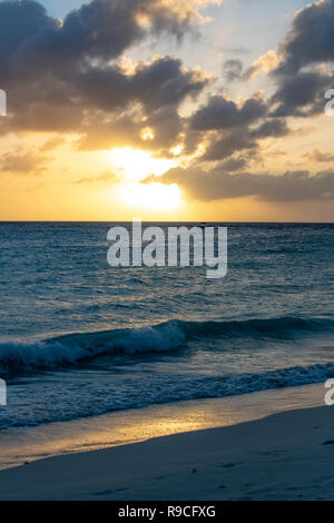 Caribbean Sunset - wunderschönen tropischen Sonnenuntergang auf der Insel Aruba-Wellen bei Sonnenuntergang, wenn die Sonne reflektiert sich auf ein ruhiges Meer mit dunkelblauen Meer Wasser Stockfoto