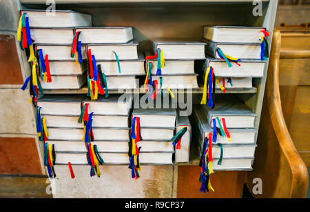 Gesangbücher mit bunten Lesezeichen in einem Holzregal Stockfoto