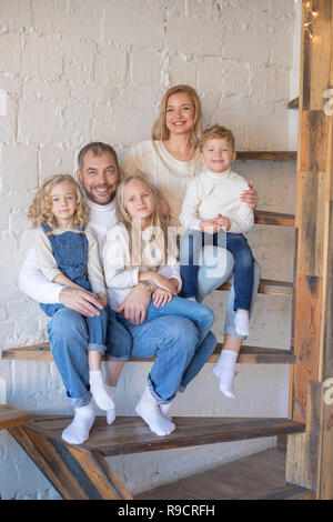 Happy Family auf der Treppe, zu Hause zu sitzen. Stockfoto