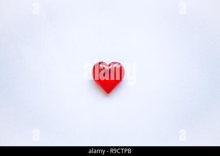 Rotes Herz auf einem weißen Hintergrund. Konzept für den Valentinstag oder Tag der Frauen oder das Thema Gesundheit, Leben, Spenden und Helfen. Im minimalistischen Stil. Stockfoto