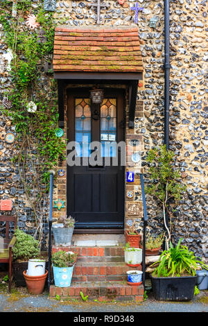 Tür zu kleinen Feuerstein und Ziegel Terrasse Haus auf der Vorderseite mit verschiedenen christlichen religiösen Symbole und Abzeichen geschmückt. Church Square, Broadstairs. Stockfoto