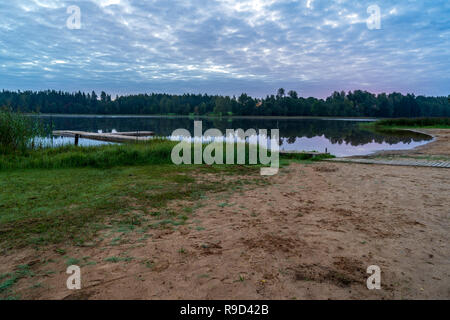 Picknick am See mit holzbrett Promenade in der Sonnenuntergang mit ruhigem Wasser Stockfoto