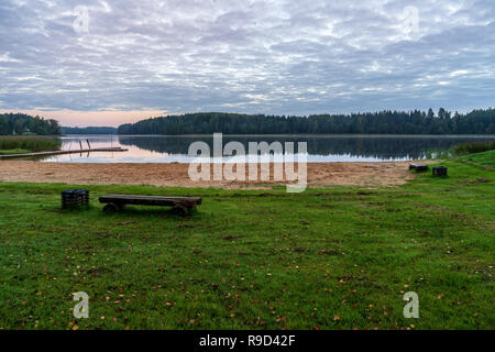 Picknick am See mit holzbrett Promenade in der Sonnenuntergang mit ruhigem Wasser Stockfoto