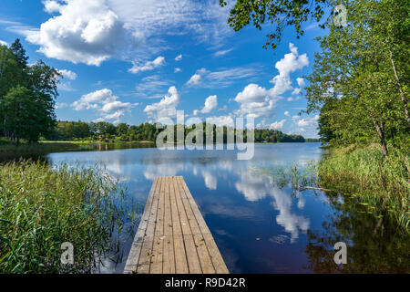 Picknick am See mit holzbrett Promenade in der Sonnenuntergang mit ruhigem Wasser Stockfoto