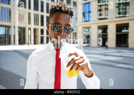 Gut aussehender Geschäftsmann trink Smoothie Stockfoto