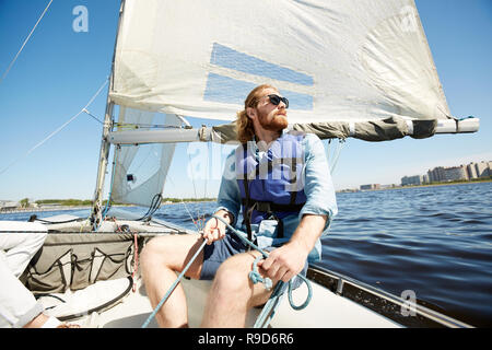 Nachdenklicher Mann mit Seil auf Segelboot Stockfoto
