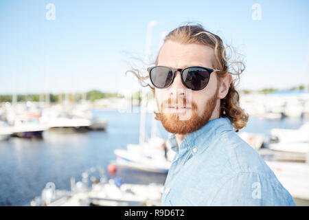 Schöner Mann in Sonnenbrille besuch Yacht Club Stockfoto