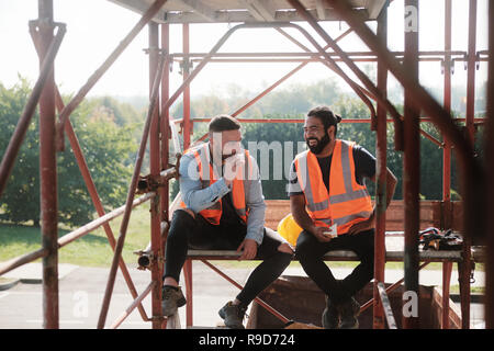 Glückliche Arbeiter in Baustelle während der Mittagspause Stockfoto