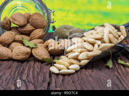 Geschälte Mandeln, mit Schale und mit Haut (almendrucos). Rustikaler Stil, auf Holz- Hintergrund. Stockfoto