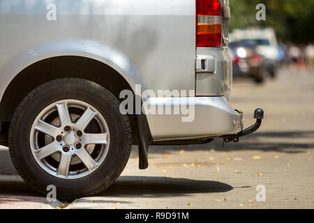 Close-up Seite Detail anzeigen Silber Passagier mittelgroß Luxus Minibus Transporter mit Zugöse auf Sommer sonnigen Stadt Straße Bürgersteig mit unscharfen Sil geparkt Stockfoto