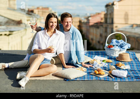 Positive Paar beim romantischen Picknick auf dem Dach Stockfoto