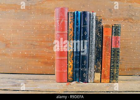 Bücher über Holz- Hintergrund über Schnee Effekt. Alte Vintage Books auf Holz- Hintergrund. Kopieren Sie Platz. Konzept der Lesung, Bildung und Still Life Stockfoto