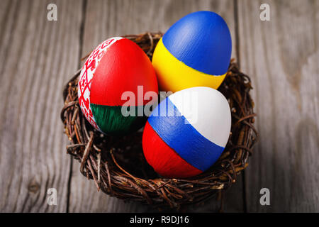 Drei Ostereier in den Farben der Flagge von Ukraine, Belarus und Russland im Nest lackiert Stockfoto