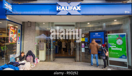 Chichester, West Sussex, UK. 22. Dezember 2018. Obdachloser sitzt mit seinen Besitz außerhalb Halifax Bank am letzten Samstag vor Weihnachten. Kredit Stuart C. Clarke/Alamy Leben Nachrichten. Stockfoto