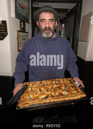 Fowey, Cornwall, UK. 23 Dez, 2018. Lokale 'Guns'Madron, als Tom Bawcock bringen traditionelle Stargazy pie in The Ship Inn in Fowey. Der fisch Pie mit Sardine Köpfe und Schwänze, stößt, ist in der Kneipe auf Tom Bawcocks Eve Die Geschichte geht, dass Tom, ein aus dem 16. Jahrhundert Fischer, trotzte Stürmen und verfing sich genug Fisch im ganzen Dorf zu füttern. Foto: Simon Maycock/Alamy leben Nachrichten Stockfoto