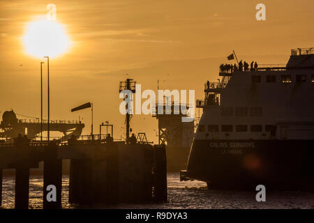 Fähren fahren in und aus dem geschäftigen Hafen - die Weihnachten weg ist in vollem Gange, als die Sonne über Dover steigt und die Fähren Überfahrt nach Calais. Stockfoto