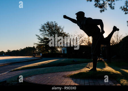 Pinehurst, North Carolina, USA. 23 Dez, 2018. Dezember 23, 2018 - Pinehurst, N.C., USA - die Statue von Payne Stewart ist gegen die aufgehende Sonne mit Blick auf den 18. Grün an der berühmten Pinehurst Nr. 2 Kurs. Die lebensgroße Bronzeskulptur von Zenos Furdakis, erinnert an Stewart's Pose nach dem Gewinn der US Open 1999 bei Pinehurst. Credit: Timothy L. Hale/ZUMA Draht/Alamy leben Nachrichten Stockfoto