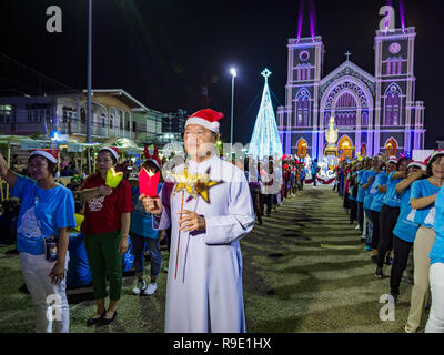 Chantaburi, Thailand. 23 Dez, 2018. Ein Priester führt die Prozession in der Kathedrale von der Unbefleckten Empfängnis Weihnachtsmarkt in Chantaburi. Die Kathedrale der Unbefleckten Empfängnis ist das jährliche Weihnachtsfest Holding, in diesem Jahr mit dem Namen "Sweet Christmas@Chantaburi 2018''. Die Kathedrale ist die grösste katholische Kirche in Thailand und wurde vor mehr als 300 Jahren durch die vietnamesischen Katholiken, die in Thailand gegründet, dann Siam. Credit: Jack Kurtz/ZUMA Draht/Alamy leben Nachrichten Stockfoto