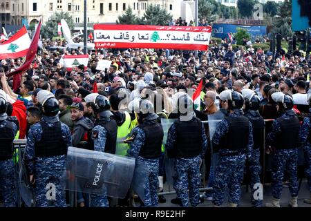 Beirut, Libanon. 23 Dez, 2018. Die Demonstranten halten Libanesische Fahnen und Banner bei einer Demonstration in Beirut, Libanon, 23 Dezember, 2018. Tausende von Demonstranten auf die Straße gingen, in Beirut am Sonntag gegen die Verschlechterung der wirtschaftlichen Rahmenbedingungen zu protestieren. Der Libanon hat gekämpft, um eine Regierung zu bilden, da Saad Hariri als Premierminister im Mai bestimmt war, mit tiefen Unterschiede zwischen den Parteien über ihre Darstellung in der neuen Regierung. Credit: Bilal Jawich/Xinhua/Alamy leben Nachrichten Stockfoto