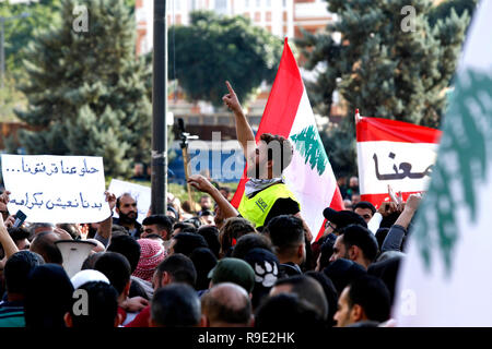 Beirut, Libanon. 23 Dez, 2018. Die Demonstranten halten Libanesische Fahnen und Banner bei einer Demonstration in Beirut, Libanon, 23 Dezember, 2018. Tausende von Demonstranten auf die Straße gingen, in Beirut am Sonntag gegen die Verschlechterung der wirtschaftlichen Rahmenbedingungen zu protestieren. Der Libanon hat gekämpft, um eine Regierung zu bilden, da Saad Hariri als Premierminister im Mai bestimmt war, mit tiefen Unterschiede zwischen den Parteien über ihre Darstellung in der neuen Regierung. Credit: Bilal Jawich/Xinhua/Alamy leben Nachrichten Stockfoto