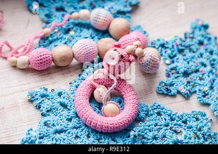 Halskette aus Gewirken Schwein gemacht und Spielzeug für das Baby im Tragetuch sitzen. Sling Halskette. Stockfoto