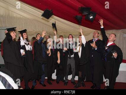 Studenten nach ihrem Abschluss an der Universität von West England werfen Caps in der Luft Stockfoto