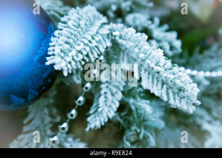 Einige Zweige der eingerichteten snowy christmas tree Blue Christmas Ball mit Highlight closeup Stockfoto