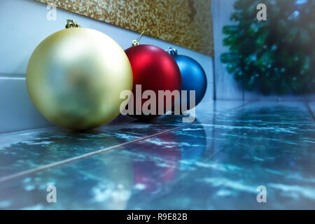 Drei Weihnachten Kugeln in verschiedenen Farben in einer Reihe liegend mit Reflexion und Platz für Text Stockfoto