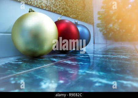 Drei Weihnachten Kugeln in verschiedenen Farben in einer Reihe liegend mit Reflexion und Platz für Text Stockfoto