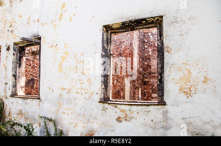 Zwei gebrochene Fenster in einem verlassenen Haus im Freien Nahaufnahme Stockfoto