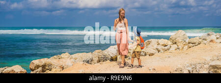 Mutter und Sohn Reisende auf erstaunliche Melasti Strand mit türkisblauen Wasser, Insel Bali Indonesien. Mit Kindern unterwegs Konzept BANNER, LANGE FORMAT Stockfoto