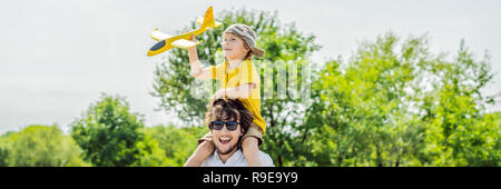 Gerne Vater und Sohn spielen mit Spielzeug Flugzeug gegen alte Landebahn Hintergrund. Mit Kindern unterwegs Konzept BANNER, LANGE FORMAT Stockfoto