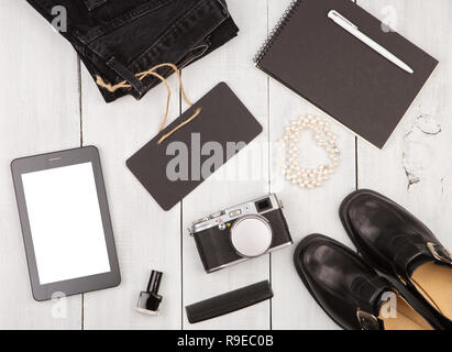 Travel Concept - Schuhe, Jeans, Tablet-PC, Kamera, Notepad, Essentials und Schwarzen Brettes auf weißen Holzmöbeln, Schreibtisch Stockfoto
