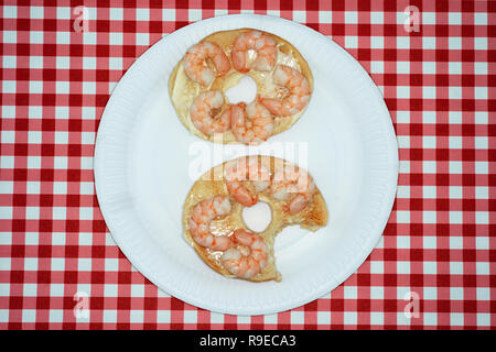 Schachfiguren mit Mayonnaise auf einem Bagel Stockfoto