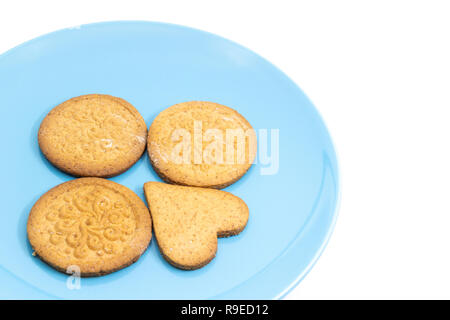 Lebkuchen Formen auf blauem Teller. Rund mit Muster und Herz geformt. Auf weiß isoliert. Stockfoto