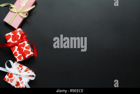 Blick von oben auf die verschiedenen Valentines Geschenk Boxen auf schwarzen Hintergrund mit kopieren. Stockfoto