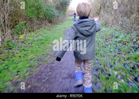 7 Jahre alter Junge zu seiner Mutter und seinem Hund auf einem Wald Wanderweg Stockfoto