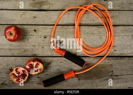 Seilspringen und Obst auf Holz- Hintergrund. Stockfoto