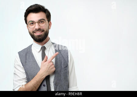 Dort Konzept. Gerne jungen gutaussehenden Mann in Vest weg zeigen und lächelnd. Stockfoto