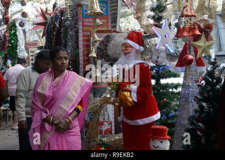 Kolkata, Indien. 22 Dez, 2018. Indische Frau Spaziergang vor einem Geschäft mit Weihnachten Reihen eingerichtet. Weihnachtstag ist ein Urlaub am 25. Dezember beobachtet die Geburt Jesu zu gedenken. Obwohl Weihnachten ist in der Regel feiert von Christian Es ist auch gefeiert, die von vielen auch nicht christlich sind. Credit: Saikat Paul/Pacific Press/Alamy leben Nachrichten Stockfoto