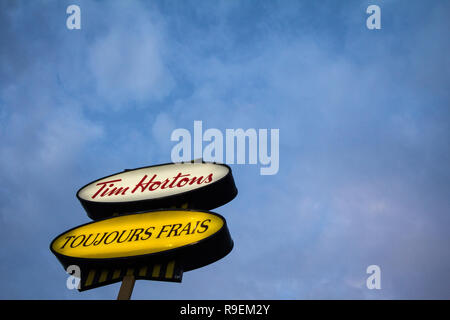 MONTREAL, KANADA - 6. NOVEMBER 2018: Tim Hortons Logo vor einem ihrer Restaurants in Quebec mit ihren Slogan in französischer Sprache. Tim Hortons ist ein Caf Stockfoto