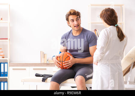 Stattliche Basketballspieler besuchen Ärztin traumatologist Stockfoto