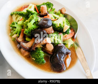 Brokkoli gekochte Shiitake-pilze/gebratene Garnelen Brokkoli Gemüse mit Austernsauce Pilze auf weiße Platte rühren Stockfoto