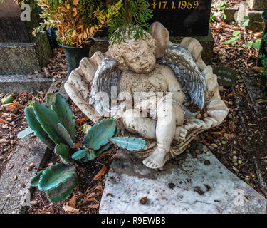 Berlin, Mitte. Dorotheenstadt protestantischen Friedhof und Beerdigung. Baby Engel Cherub, in der Schale, Porzellan Skulptur auf dem Grab. Stockfoto